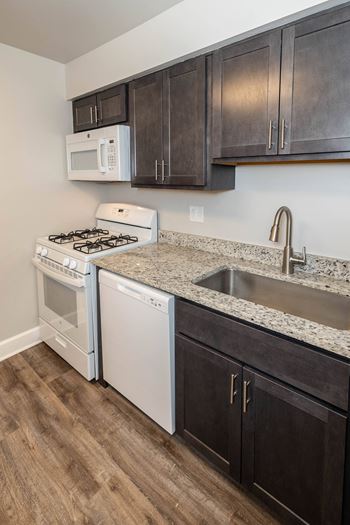 Kitchen with white appliances and dark wood cabinets